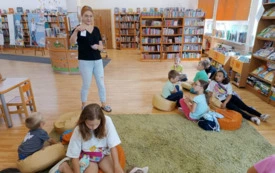 Dzieci pr&oacute;bują dopasować nazwy planet do zdjęć, wszyscy siedzą na dywanie podzieleni na grupki